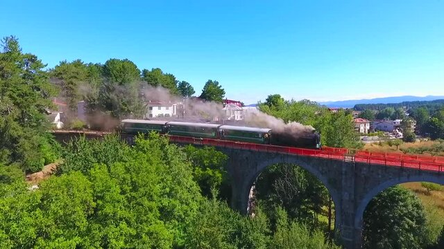 locomotiva a vapore ripresa dal drone sopra al ponte della ferrovia