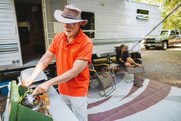 Older man boiling water on campstove
