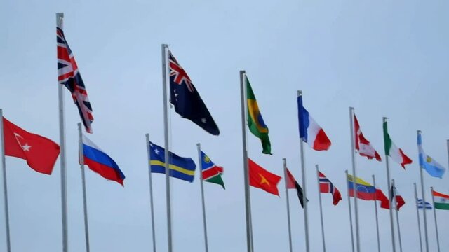 Many colorful flags of different countries waving in the wind