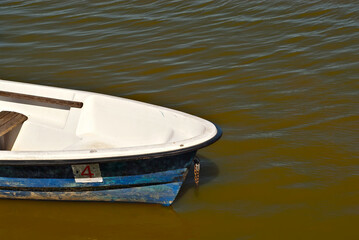 Obraz premium Old white boat on the lake near the pier.