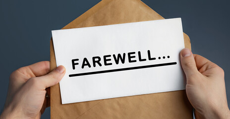 Cropped view of man holding craft envelope with text FAREWELL on blue background