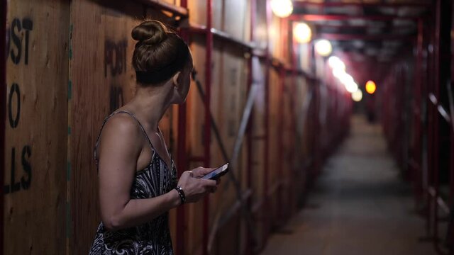 Woman waiting in Creepy Alley with Smartphone