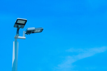 Solar cell lamp, lamp-based illumination Two solar panel powered LEDs mounted in a 90 degree position with a blue sky background.