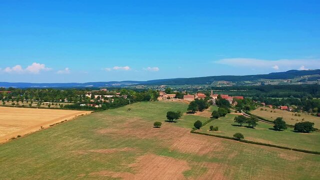 Slow forwards moving drone shot of wheat fields, near small village Taize in France.