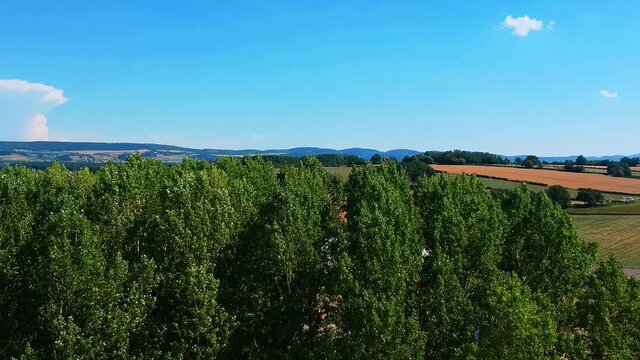 downwards moving shot of fields in France, near a village Taize, downwards movement ends in trees.