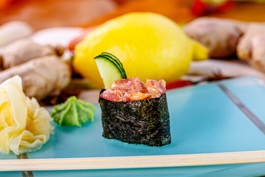 Tuna guncan with sauce on a plate. Wasabi and ginger nearby