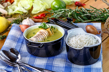 Curry soup with mushrooms and chicken is poured into a plate, next to rice