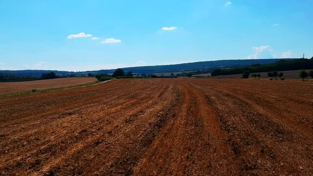 Fast forward moving shot of a field, brown color, near Taize village in France.