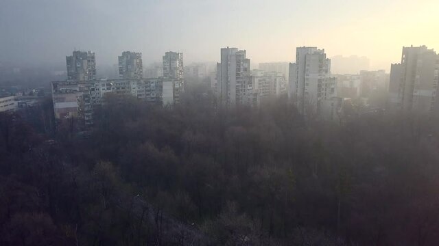 Flying over a concrete living apartment area in east Europa with many birds flying around the drone