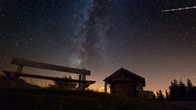 Motion controlled timelapse of the milkyway with a bench in the foreground.