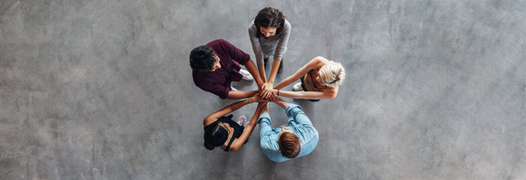 Young people making a stack of hands