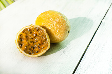 Passion fruit, marakuja żółty tropikalny owoc na jasnym tle, w mocnym świetle.
