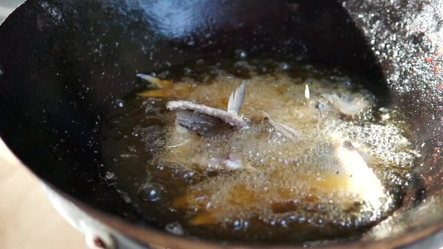 Slow motion capture of deep frying freshly caught reef fish called the Hawaiian flagtail or Aholehole for dinner or appetizers.