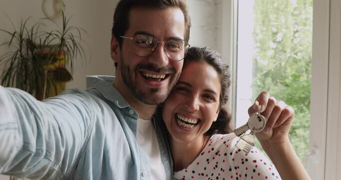 Husband holds device record videoblog share happy moment of family moving for internet subscribers wife show bunch of keys from new house close up webcam view. Capture moment of relocation day concept