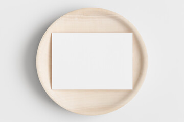 White invitation card mockup on a wooden plate. 5x7 ratio, similar to A6, A5.