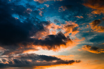Beautiful sunset. Black and orange clouds in the dark blue sky