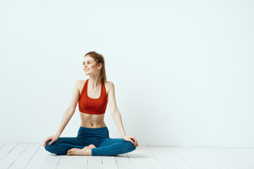 Fototapeta premium athletic woman in pose on the floor exercise gymnastics performance light background