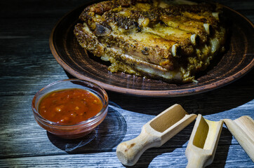Still life with coocked pork ribs on the wooden desk