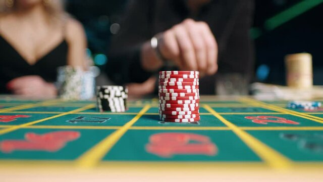 casino, gambling, poker, people and entertainment concept - close up of poker player with chips at green casino table