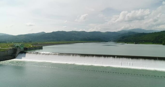 Aerial drone view of water flow of dam reservoir of National Irrigation Authority built to produce hydroelectric energy in San Roque Dam, in Pangasinan, Philippines