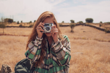 A beautiful model takes a photo with an analog camera