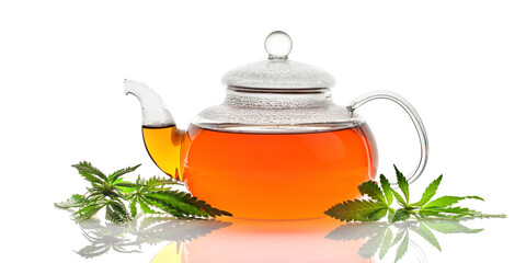 Cannabis herbal tea and marijuana leaves on white background. 