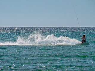 Obraz premium Kite Surfing through the afternoon sun with silhouette contours