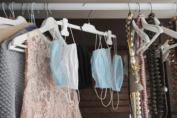 Different protective face masks hanging  with clothes