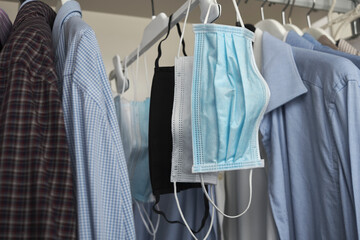 Different protective face masks hanging  with clothes