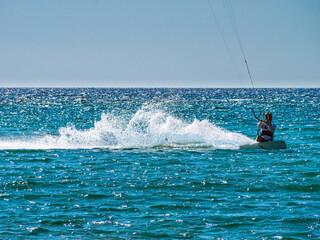 Obraz premium Kite Surfing through the afternoon sun with silhouette contours