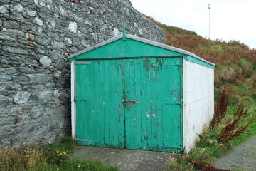 White and green beach hut with wooden door