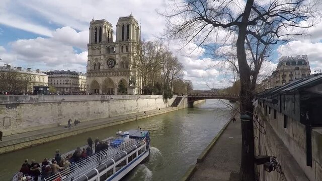 River boat cruising up the sena river in front of Notre Dame Cathedral in Paris