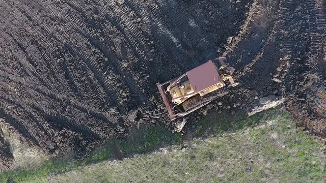 Bulldozer pushing dirt onto hill to rebuild its elegance