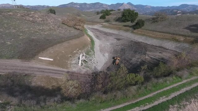 towed scraper hauling mud behind a D5 bulldozer in the green hills