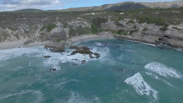 Epic aerial view of the beach and the cliffs at Walker Bay and Klipgat Cave in Gansbaai, South Africa