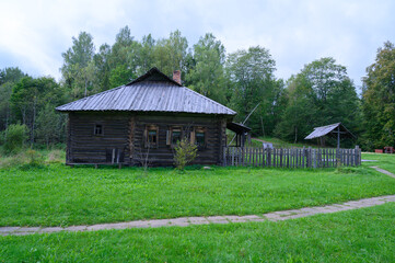 Ancient northern russian wooden cabins and churches in the wood near the river