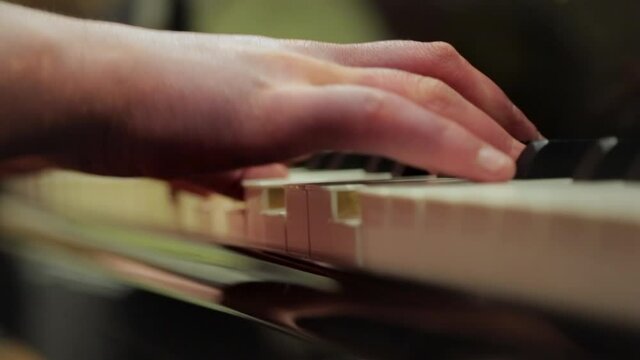 Close-up of someone playing the piano. Camera slowly moving from right to left.