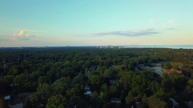 Distant view of Toronto from drone over Mississauga suburbs at dusk