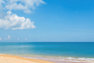 Fototapeta premium Beautiful golden sandy beach, blue sea and light blue sky with cumulus clouds.
