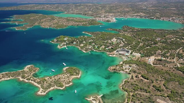 Aerial drone video of famous and picturesque yacht dock seaside fjord village of Porto Heli with turquoise and emerald clear waters, Argolida, Peloponnese, Greece
