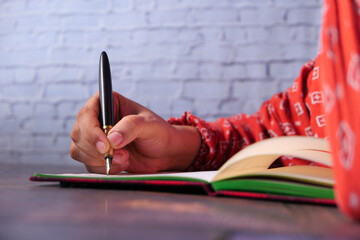 Close up of women hand writing on notepad.