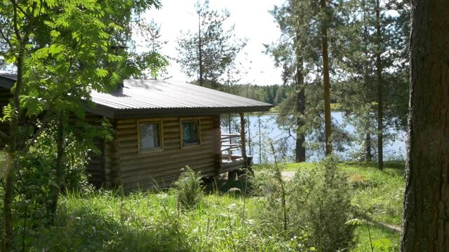 Sunny view of a lakeside log cabin in skandinavia