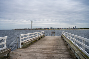 Naklejka premium A wooden jetty with blue ocean and sky in the background. Picture from Malmo in southern Sweden