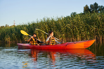 Couple of kayakers swimming during sunset
