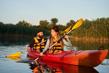 Couple of kayakers swimming during sunset © Yakobchuk Olena