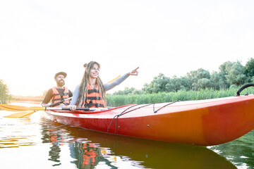 Beautiful young couple kayaking on lake