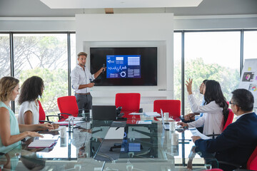 Young businessman giving presentation in meeting room at modern office