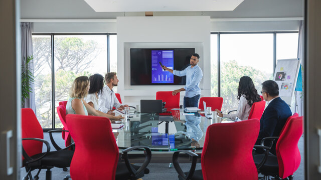 Young businessman giving presentation in meeting room at modern office