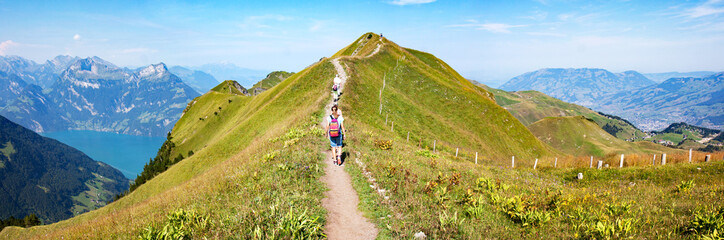 Hikers on the ridge walk along Lake Lucerne near Stoos, Switzerland, between Klingenstock and Fronalpstock (1.922m.); impressive views on the Alps