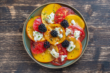Colorful summer salad with tomatoes, nectarines, blackberry and feta cheese , close up